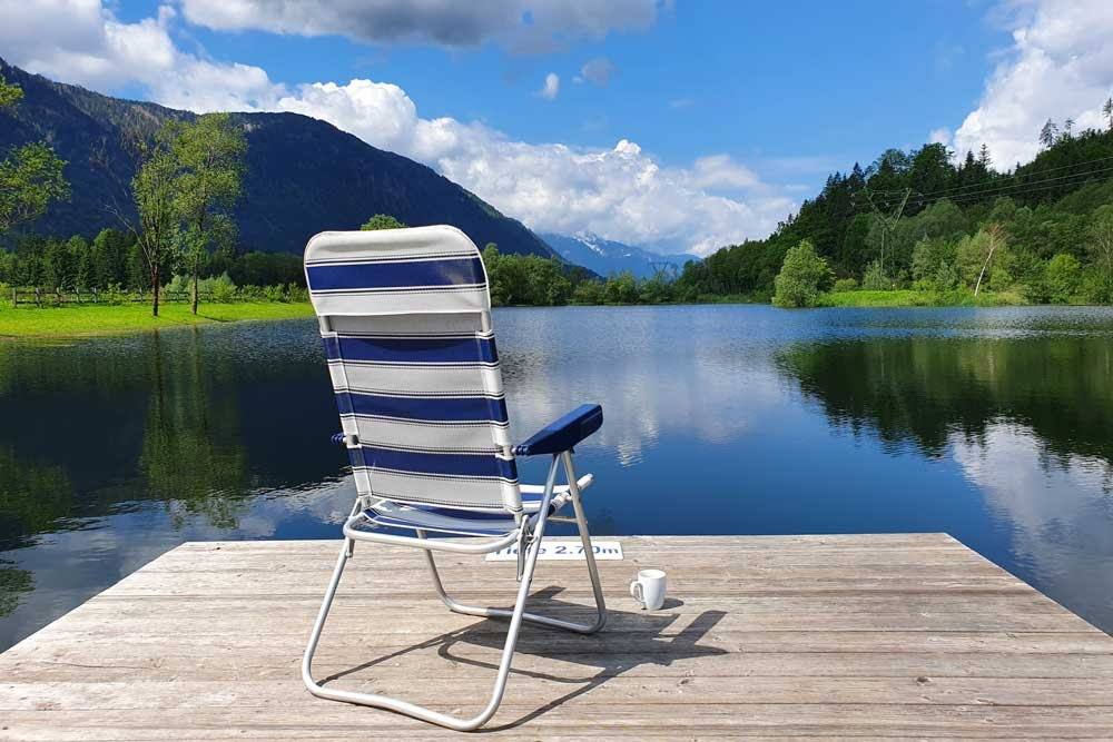 Liegestuhl auf dem Steg mit Blick über den Badesee