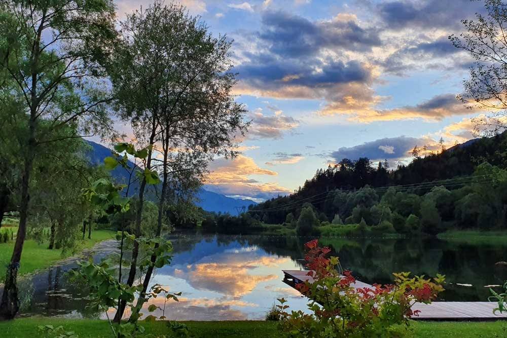 Abendstimmung am Badesee mit Spiegelung der Berge
