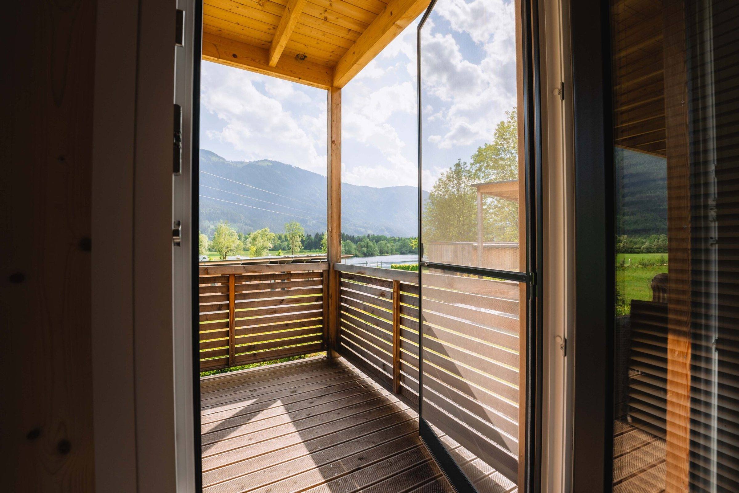 Überdachte Holzterrasse eines Wood Cube mit Bergblick